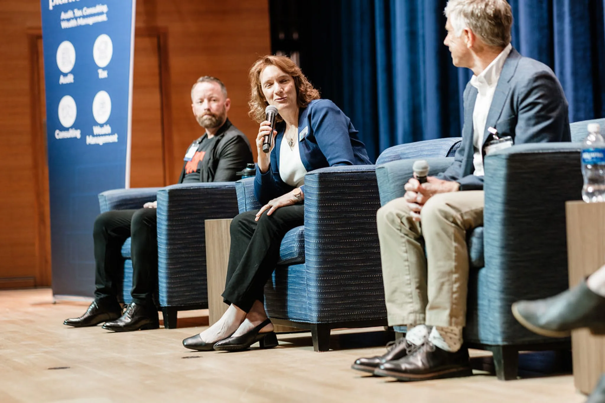 Tanya Ramond, MBA, PhD speaking into a microphone on a deep tech panel on stage.
