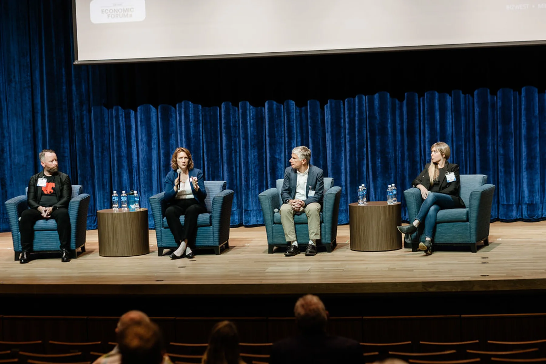 Tanya Ramond, MBA, PhD speaking on a four-person panel at a BizWest Economic Forum in Colorado, seated on stage before an audience.