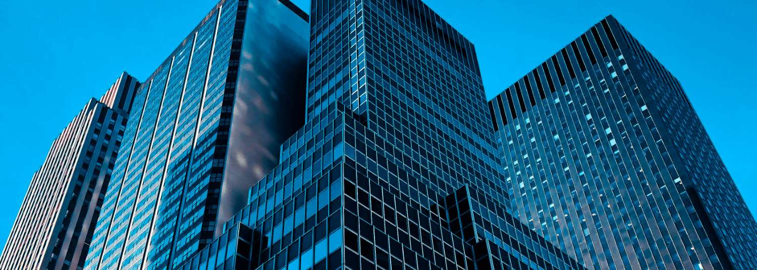 Glass corporate towers photographed from below against a clear sky, home to enterprise R&D and innovation leaders.