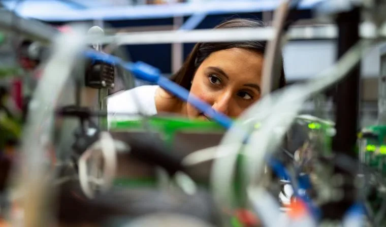 Deep tech founder inspecting prototype hardware and cabling inside a research lab.
