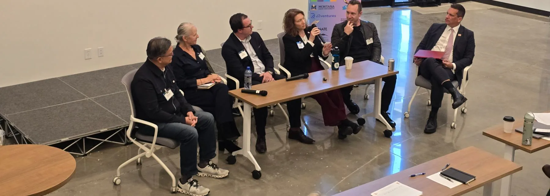 Program directors and investors on stage at a photonics and quantum startup pitch competition in Colorado.